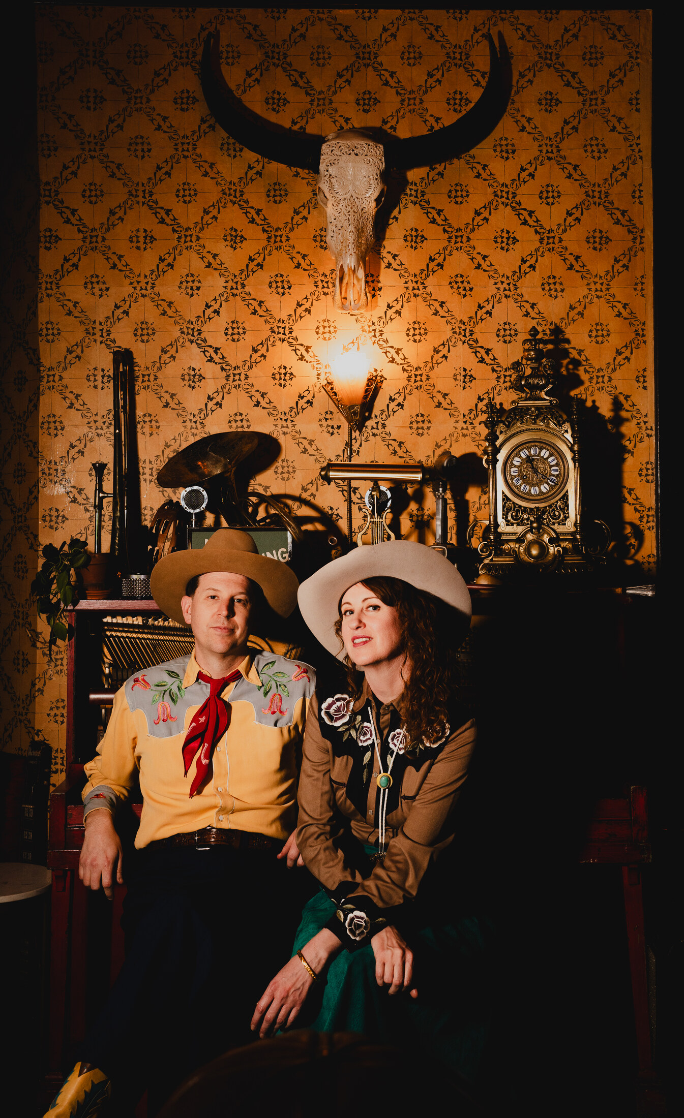 The Farmer and Adele seated together beneath a longhorn skull