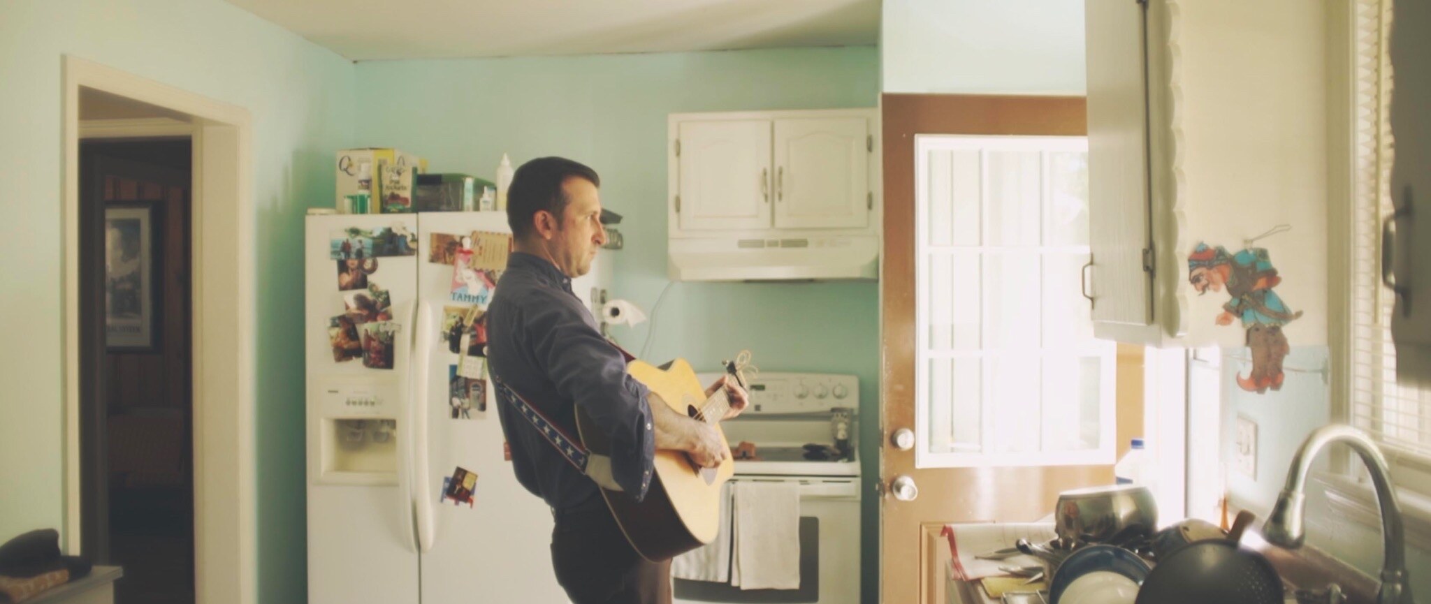 Matt Campbell playing guitar in his kitchen