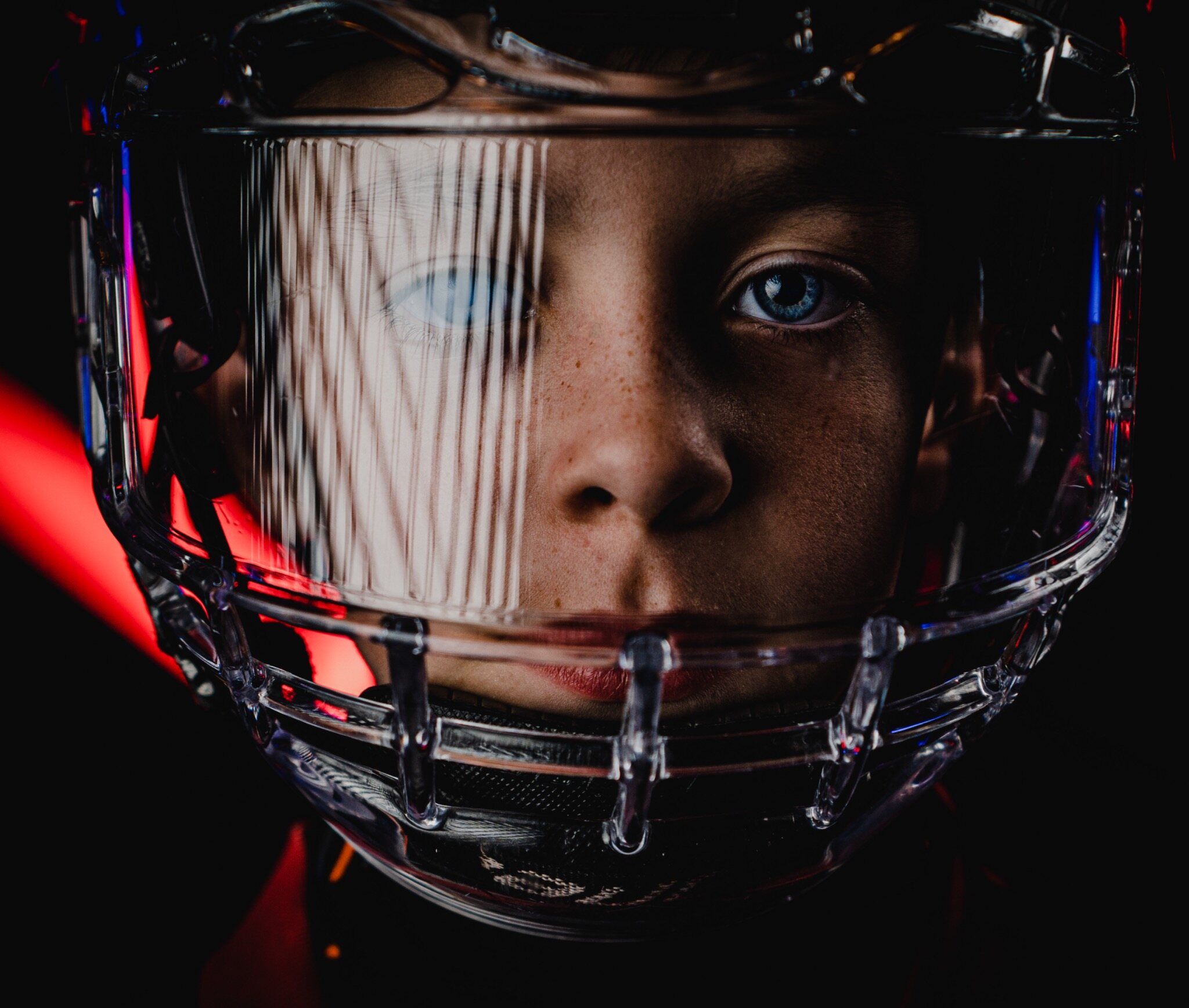 Young athlete framed closely through a football helmet