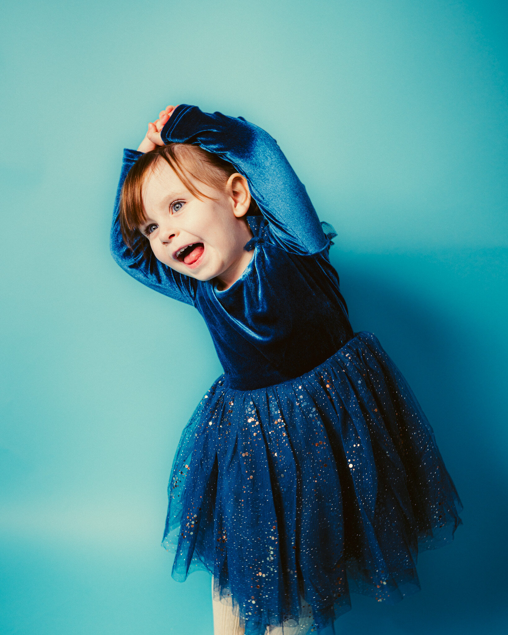 Expressive child portrait in a blue velvet dress