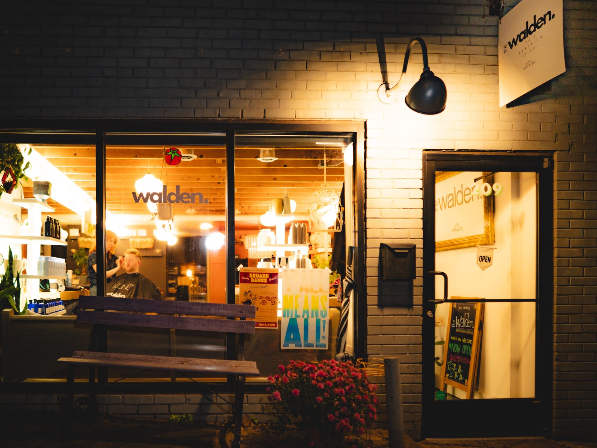 The warmly lit exterior of The Walden Salon