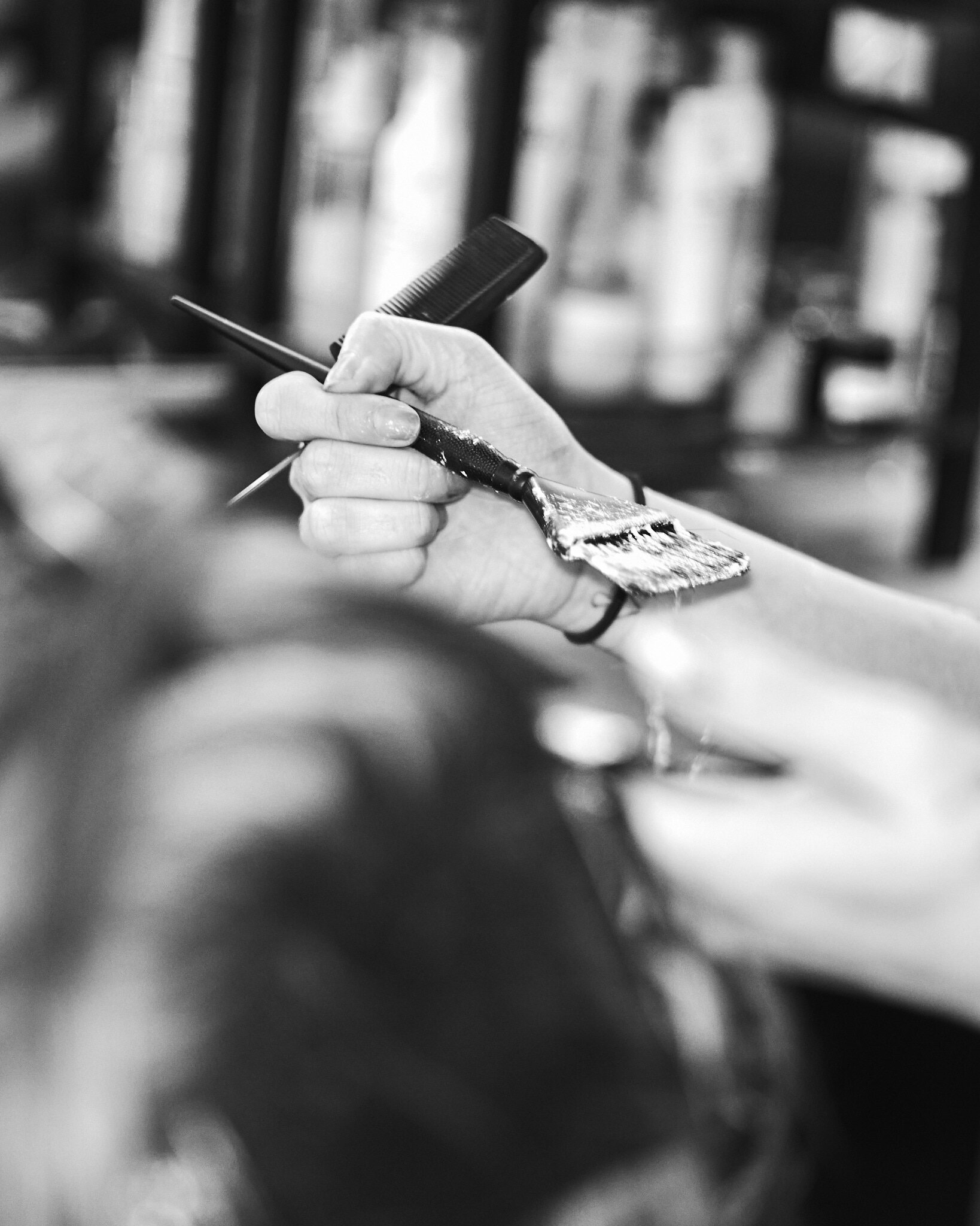 A close detail of a stylist's hand and comb